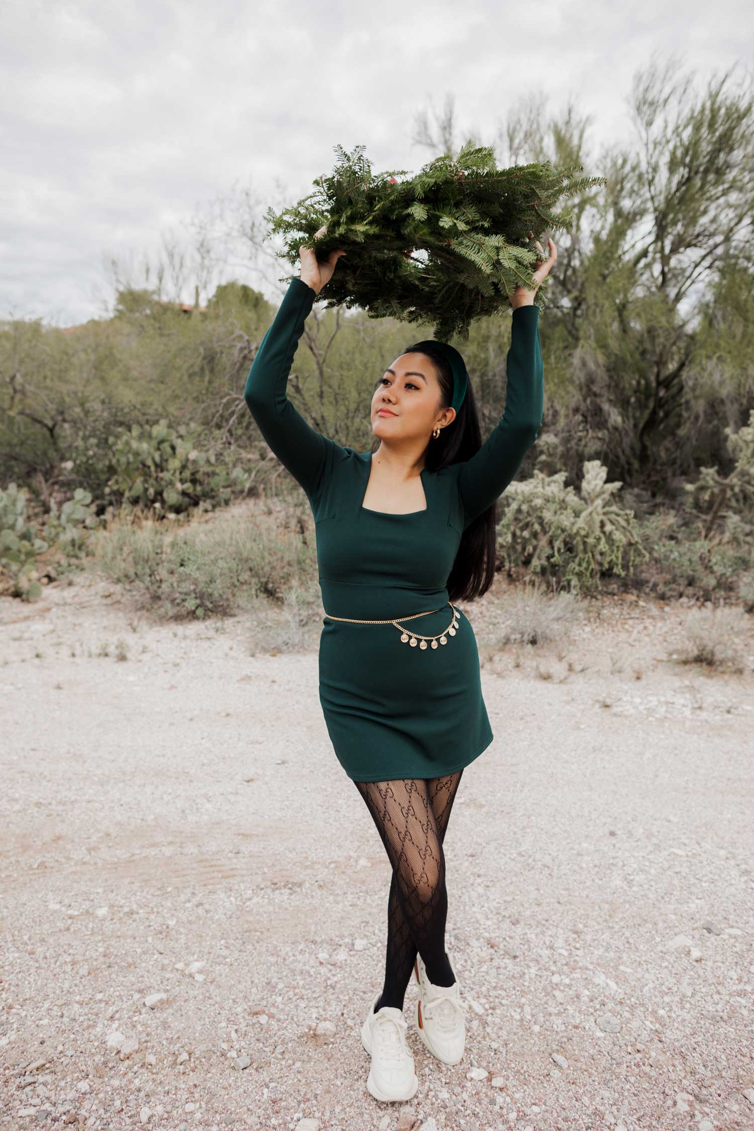 Molly larsen lifestyle blogger standing in a green dress holding a Christmas wreath in the Arizona desert Green Dress, Emerald Green Dress