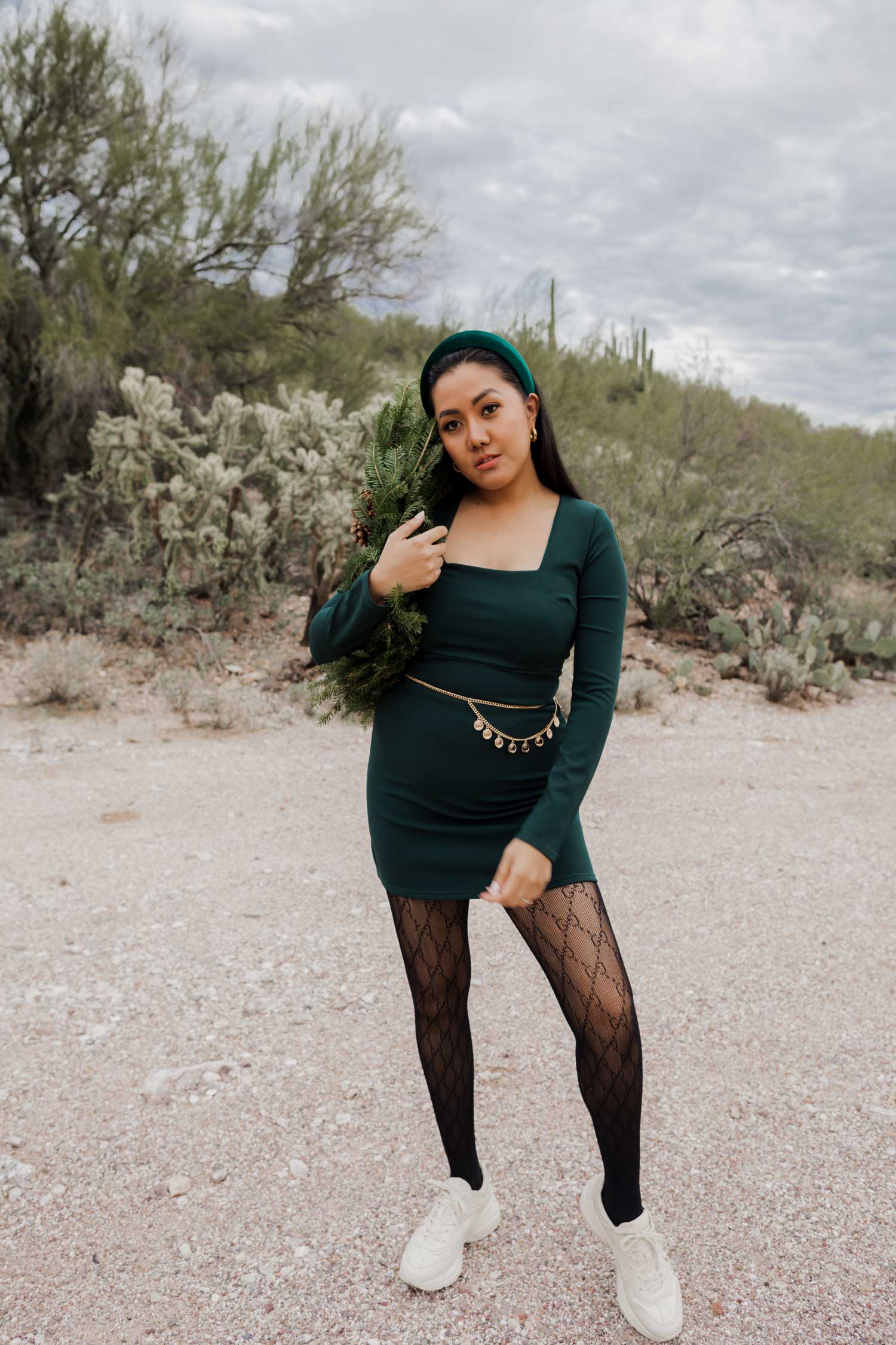 Molly larsen lifestyle blogger standing in a green dress holding a Christmas wreath in the Arizona desert Green Dress, Emerald Green Dress