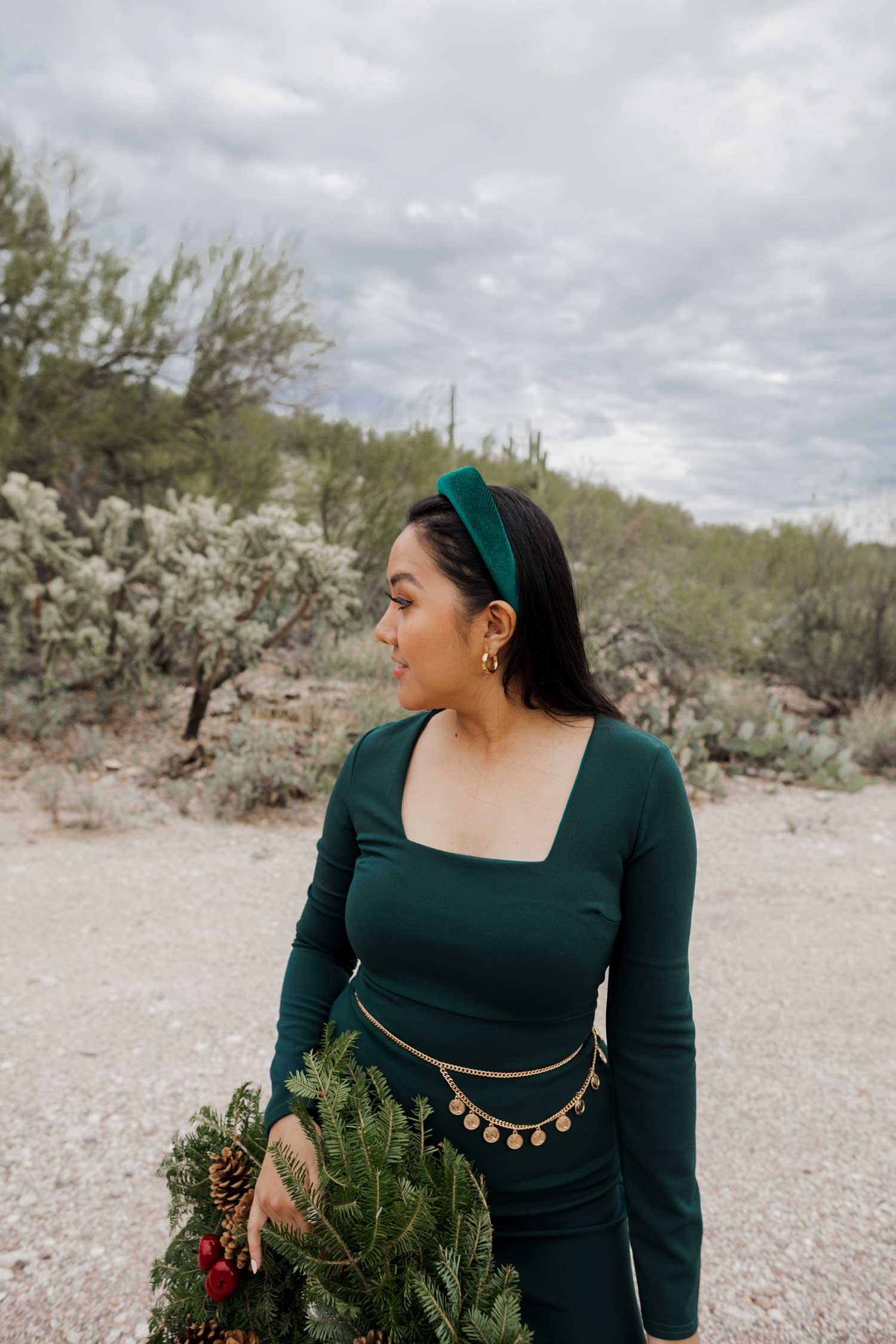 Molly larsen lifestyle blogger standing in a green dress holding a Christmas wreath in the Arizona desert Green Dress, Emerald Green Dress